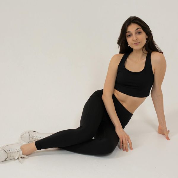 Woman in activewear performing a light cardio exercise in a bright studio.